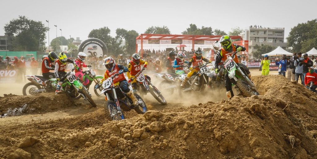 motocross bikes racing around the first corner at a race